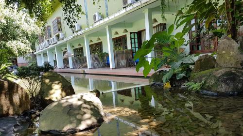 a building with a pond in front of it at Cat Tien Jungle Lodge in Cat Tien