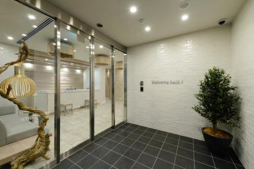 a hallway with a potted tree in a building at Hotel Il Fiore Kasai in Tokyo