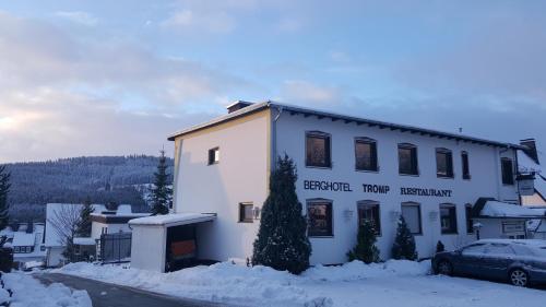 a building in the snow with a car in front at Berghotel Natura Bed & Breakfast in Winterberg