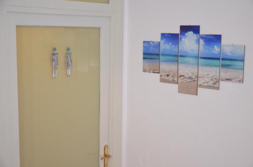 a room with a door with four paintings on the wall at Hotel Etnea Royal Suites in Catania