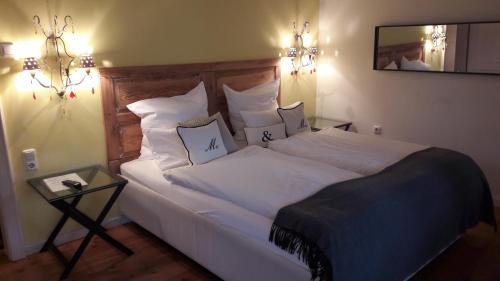 - une chambre dotée d'un grand lit avec des draps et des oreillers blancs dans l'établissement Pension Prinz, à Munich