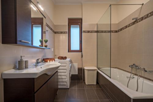 Gállos的住宿－All Seasons Villas，带浴缸、水槽和淋浴的浴室