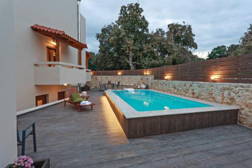 a swimming pool in a backyard with a house at All Seasons Villas in Gállos
