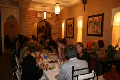 eine Gruppe von Menschen, die an einem Tisch in einem Restaurant sitzen in der Unterkunft Dar Soukaina in Marrakesch