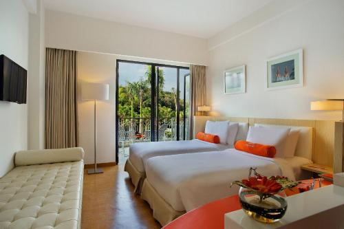 ein Hotelzimmer mit einem großen Bett und einem Sofa in der Unterkunft HARRIS Hotel & Conventions Malang in Malang