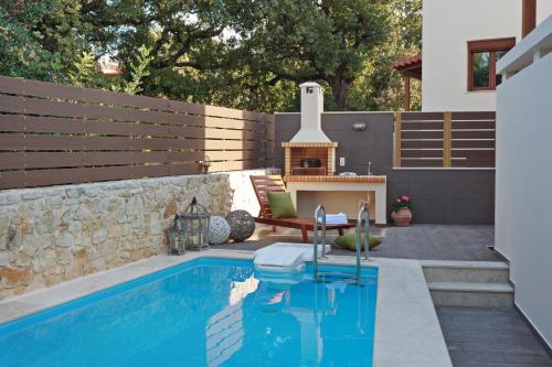 a swimming pool with a fireplace in a backyard at All Seasons Villas in Gállos