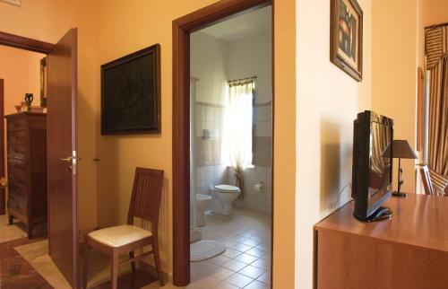 two images of a bathroom with a toilet and a television at B&B Villa Casablanca in Enna
