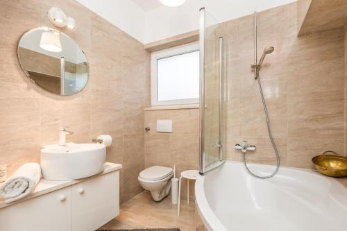 a bathroom with a tub and a toilet and a sink at Villa Lovran, heated pool and Spa in Lovran