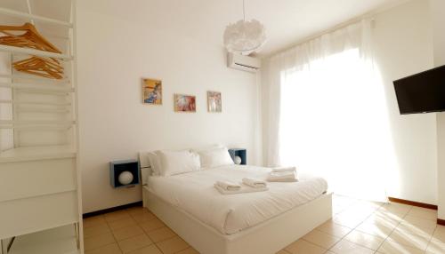 een witte slaapkamer met een bed en een raam bij Italianway-Bergognone 47 Flat in Milaan