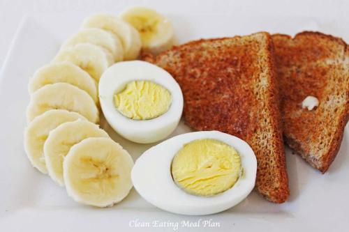 a white plate with eggs and bananas and toast at Lake Land Guest House in Kolkata