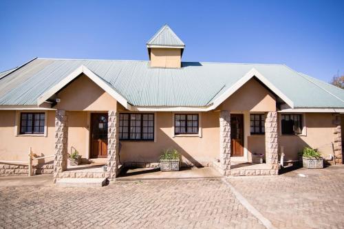 a house with a brick driveway in front of it at Auldstone House in Dullstroom