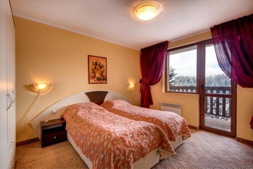 1 dormitorio con 2 camas y ventana en Mountain Lodge Apartments, en Pamporovo
