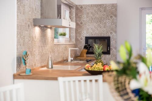 a kitchen with a counter with a bowl of fruit at Villa Lovran, heated pool and Spa in Lovran