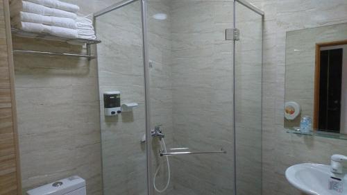 a shower with a glass door in a bathroom at Taitung Tourist Inn in Taitung City