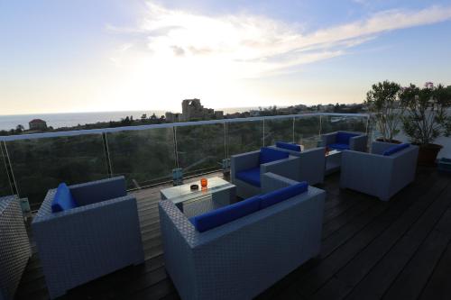 a deck with blue chairs and a table on a balcony at Aleph Boutique Hotel in Jbeil