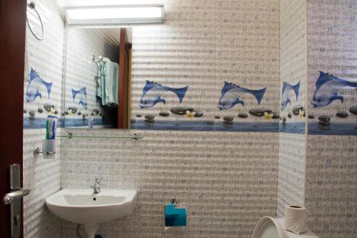 a bathroom with a sink and a toilet and a mirror at Kenendia Hotel in Kampala
