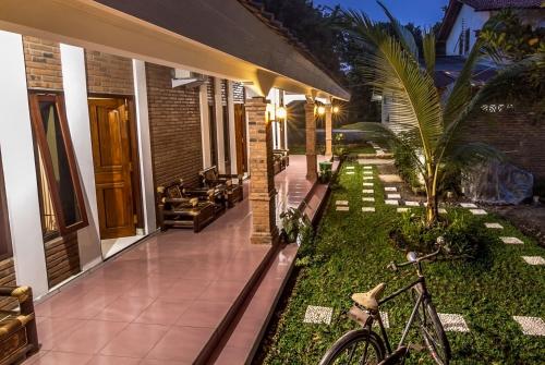 a house with a bike parked in front of it at Kumojoyo Homestay in Borobudur