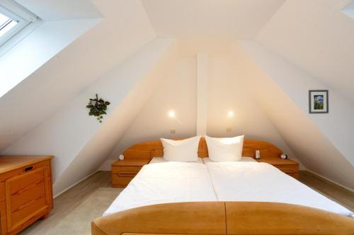 a bedroom with a large bed in a attic at Wohnung-Wattseite in Munkmarsch