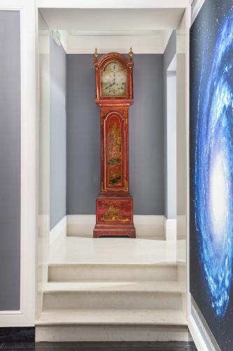 a grandfather clock in a room with stairs at Art Hotel Orologio in Bologna