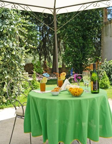 a table with a green table cloth and a bottle of wine at B&B Villa Casablanca in Enna