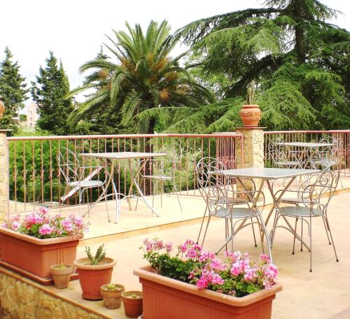 a patio with tables and chairs and flowers in pots at B&B Villa Casablanca in Enna