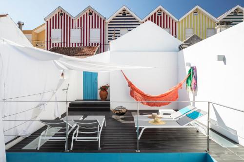a balcony with chairs and a table and a hammock at M Costa Nova in Costa Nova