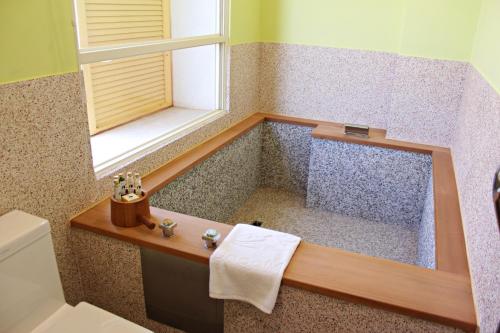 a bathroom with a tub with a window and a sink at 星月文旅溫泉民宿 in Houli