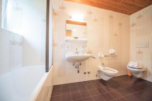 a bathroom with a sink and a toilet and a shower at Alpin Garni die kleine Post in Solda