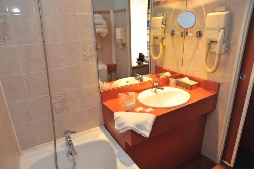 La salle de bains est pourvue d'une baignoire, d'un lavabo et d'une douche. dans l'établissement Hotel Menton Riviera, à Menton