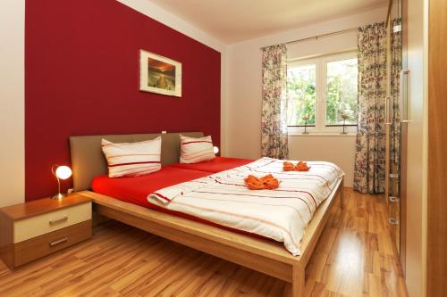 a bedroom with a large bed with red walls at Ferienwohnung Seestraße in Zempin