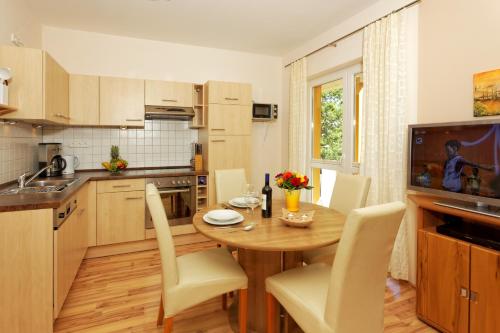 een keuken met een houten tafel met witte stoelen en een eetkamer bij Ferienwohnung Seestraße in Zempin