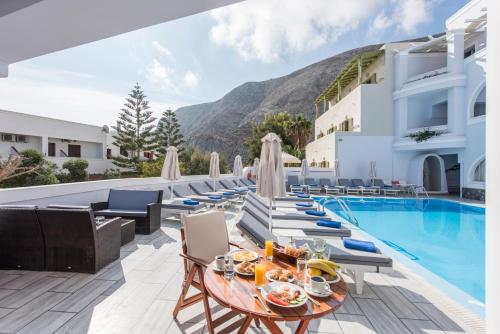 a view of the pool at a resort with a table and chairs at Blue Waves Suites & Apartments in Kamari