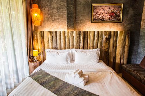 a bedroom with a bed with a stuffed animal on it at Andalay Beach Resort Koh Libong in Ko Libong