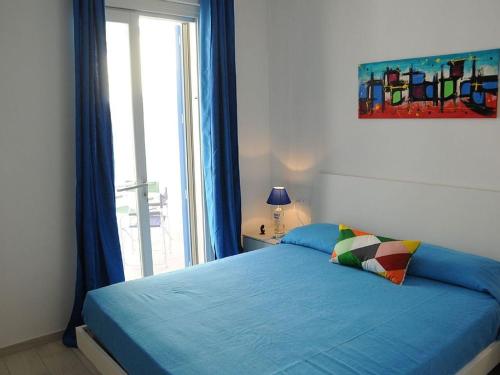 a bedroom with a blue bed with a window at Casa vacanza Irma Dario in San Vito lo Capo