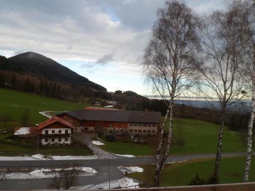 a building in the middle of a field with a road at Berggasthaus Kraxenberger in Brannenburg