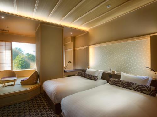 a hotel room with two beds and a window at Saka Hotel Kyoto in Kyoto