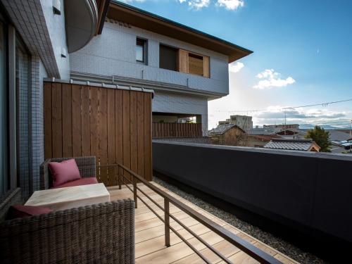 a balcony with a chair and a fence on a house at Saka Hotel Kyoto in Kyoto