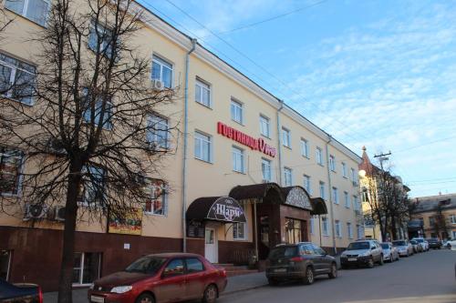 een gebouw in een straat waar auto's voor geparkeerd staan bij Гостиница ОКА in Kaloega