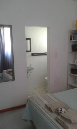 uma casa de banho com uma cama, um espelho e um lavatório. em 50 on Theal em Parow