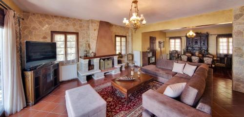 a living room with a couch and a tv at Infinity Villa Ioannina in Ioannina