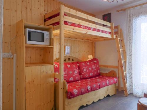 a bedroom with a bunk bed and a tv at Residence Les Erines in Méribel