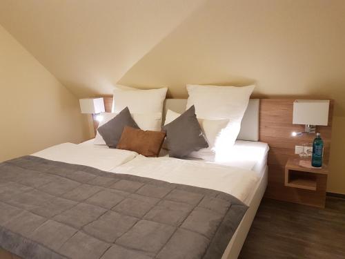 a bedroom with a large bed with white sheets and pillows at Hotel & Restaurant Sparta in Oldenburg