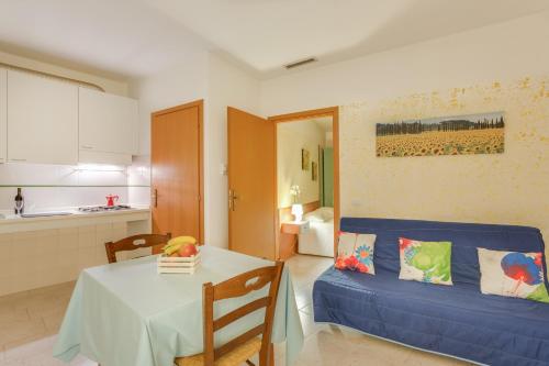 a living room with a table and a kitchen at Villaggio Mare Si in Follonica