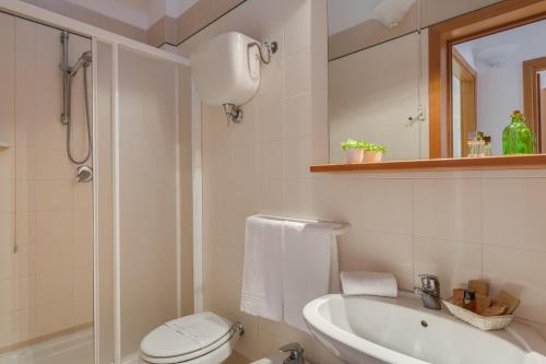 a bathroom with a toilet and a sink and a mirror at Villaggio Mare Si in Follonica