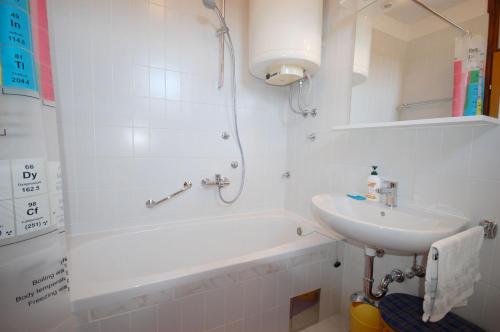 a white bathroom with a sink and a bath tub at Mezlar Apartment by El-pi Tours in Njivice