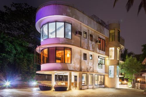 a building with a purple dome at night at The Boulevard by StayVista - A city-center villa boasting a private plunge pool, Jacuzzi & a revitalizing rain shower in Lonavala