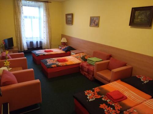 a room with four beds and a couch and chairs at Guest House U Zámku in Slatiňany