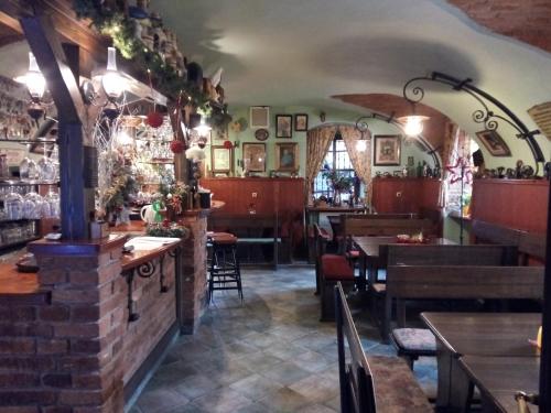 a restaurant with a bar with tables and chairs at Guest House U Zámku in Slatiňany