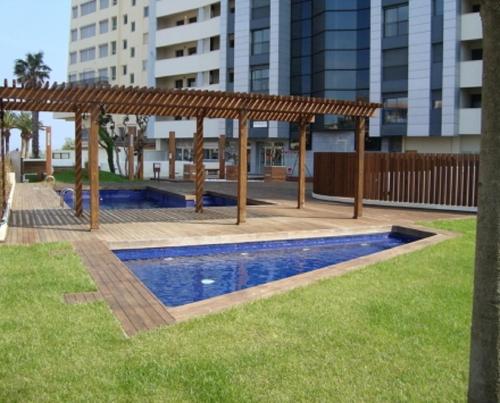 a pergola over a swimming pool in a park at Goldhome - Cristallmar in Empuriabrava