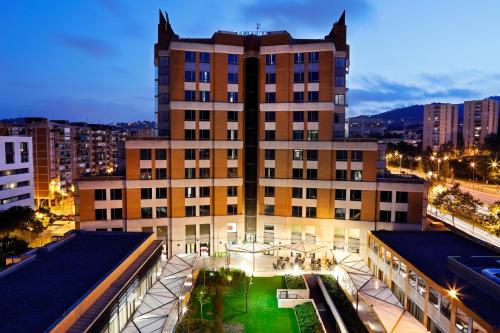 a large building with a green lawn in front of it at Hotel Alimara in Barcelona